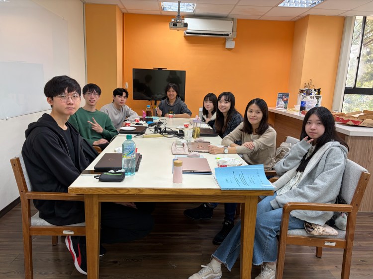 A group of Learning and Immersive Technology Lab members at NTHU sharing pizza at a Christmas gathering.